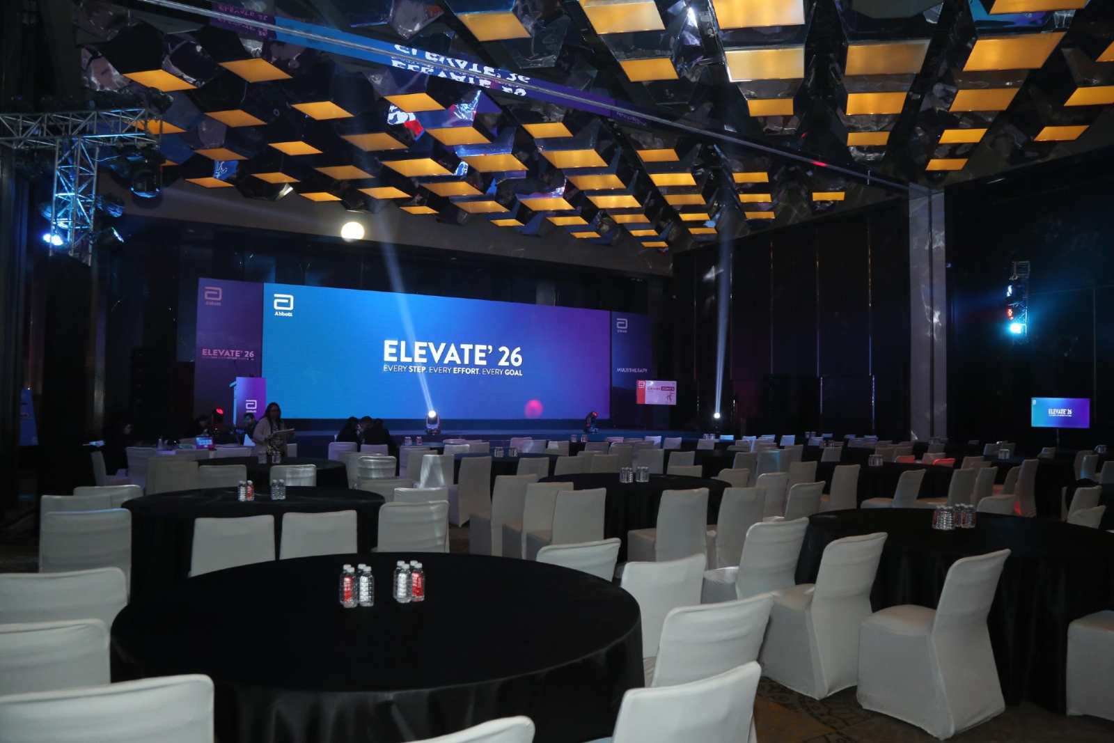Abbott Elevate 26 - mirrored ceiling treatment over a banquet-set conference floor